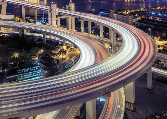 Brightly lit highway bridges with streams of light left by cars