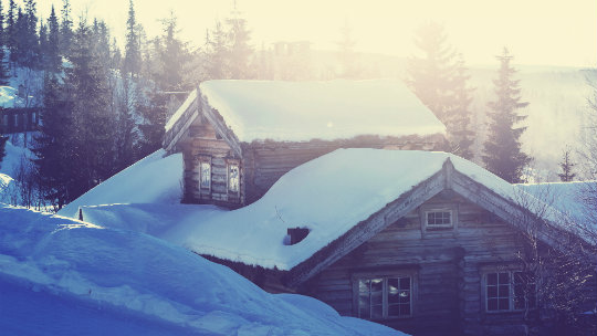 Snødekt hytte i sollys