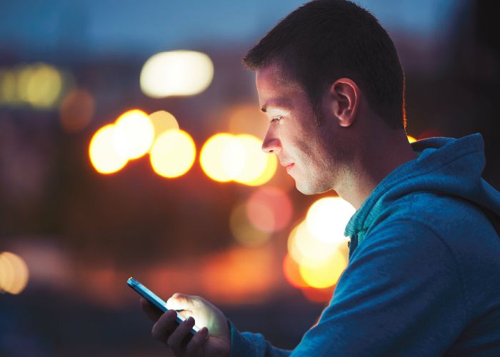 Young man using the DEFA app on a mobile phone