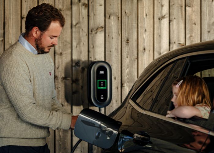 man plugs ev charger in to car
