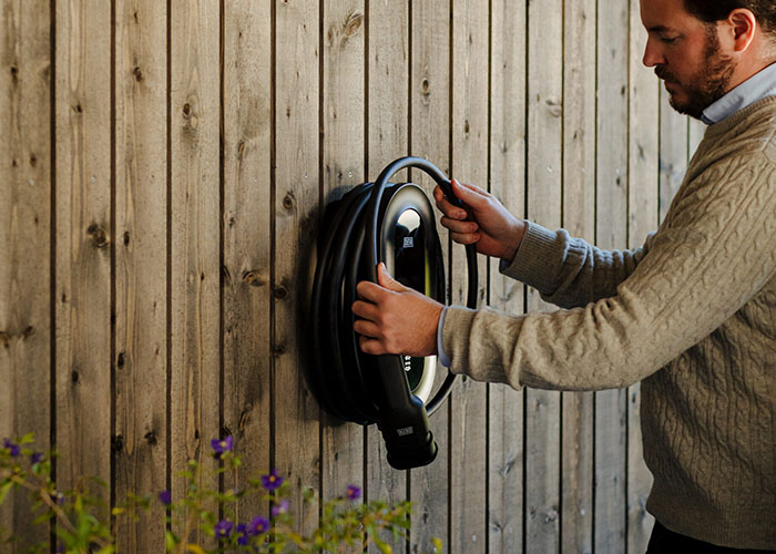 Man hännger upp laddkabel på laddbox Defa Power, minatyr