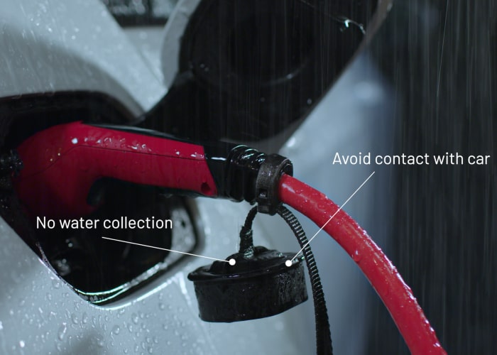 Retractable cap on charging plug with text - avoids water collection and contact with the car.