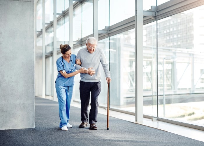 Doctor supporting an elderly man while walking