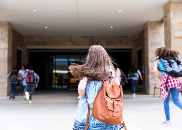 Skoleelev på vei inn skoleinngang