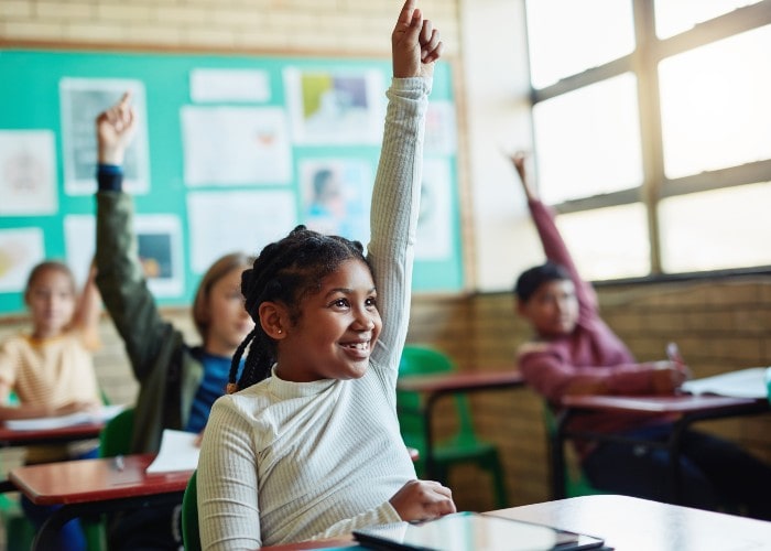 Smiling girl with a raised hand