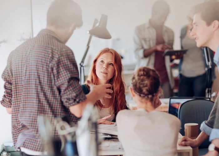 Colleagues talking in open office