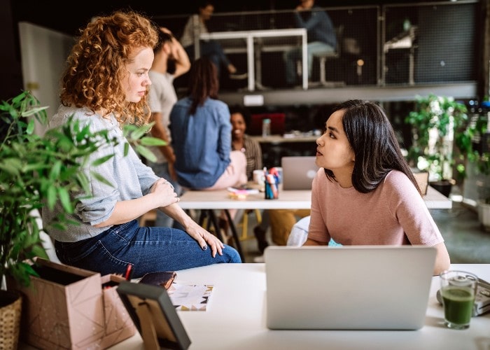 Colleagues talking in open office