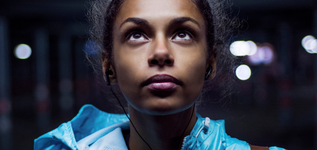 Young woman looking up at a street light