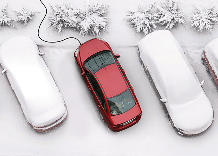 Une voiture sèche et chaude équipée de WarmUp dans un parking en hiver, à côté de voitures recouvertes de neige.