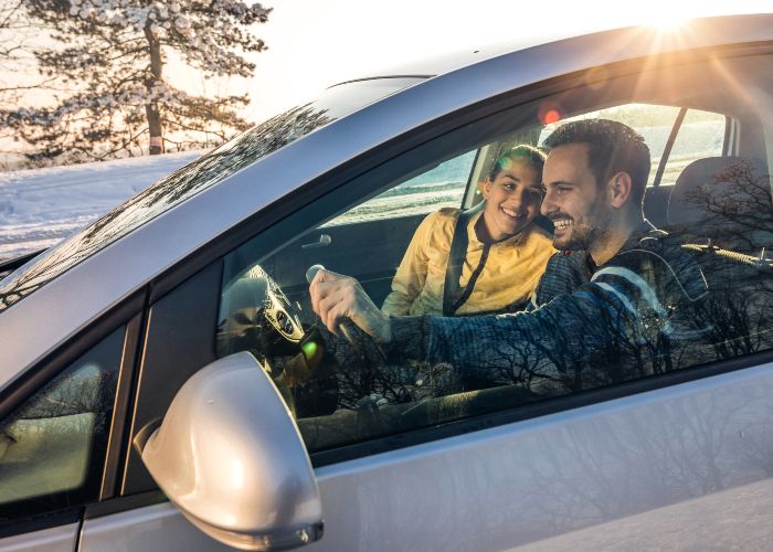 Smiling couple in car on winters day