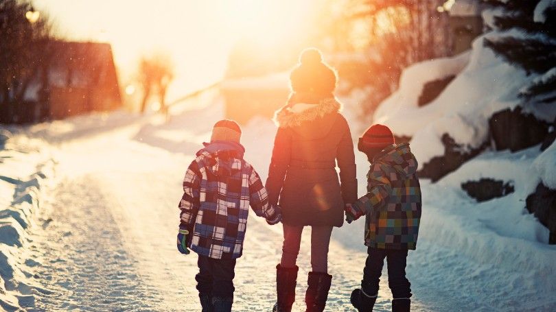 Three kids walking on a winter road